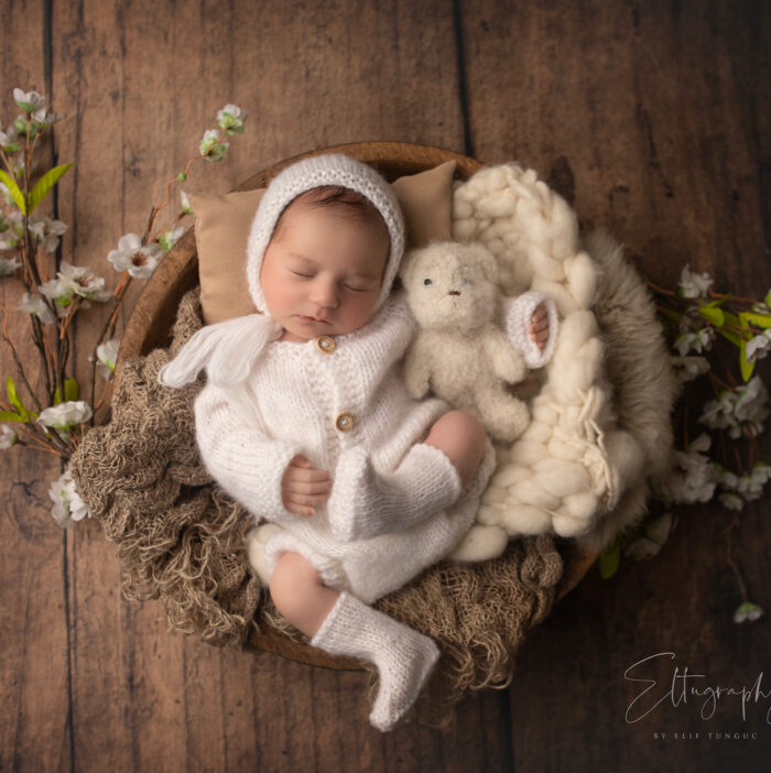 neugeborenes babyfoto mit weißem babykleidkonzept im korb