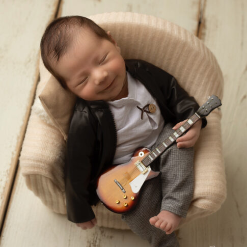 Foto des neugeborenen Babys mit Gitarrenkonzept